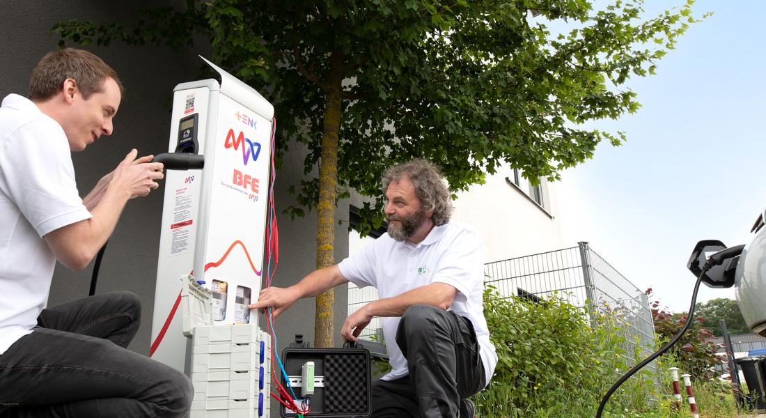 Zwei Männer arbeiten an der Ladesäule