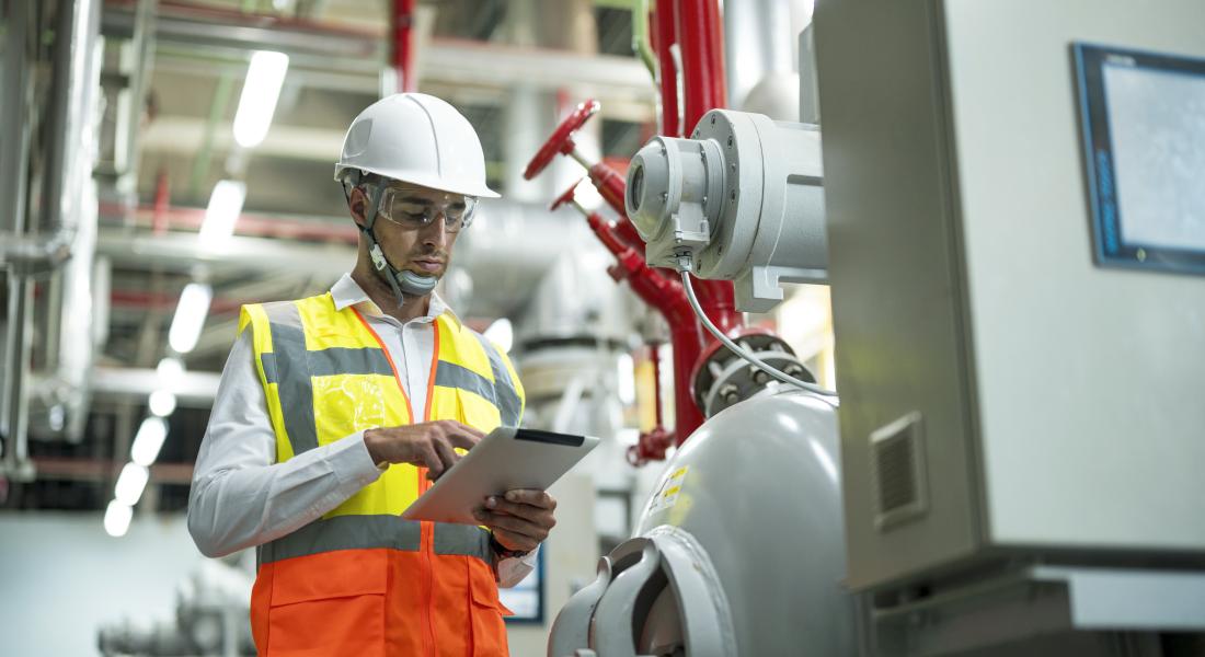 Mann an Ipad vor Heizungsanlage