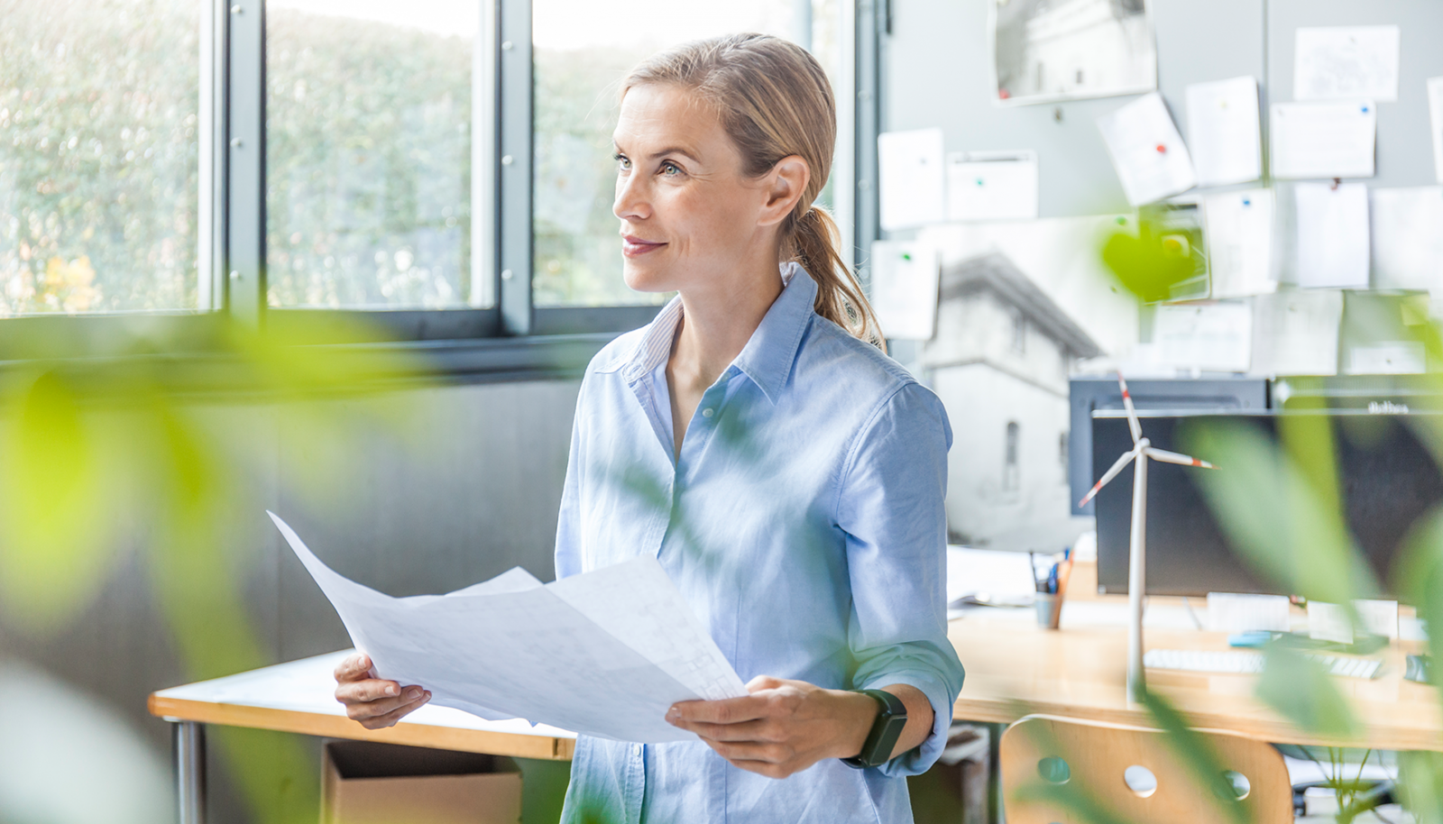 Frau im Büro hält Unterlagen in der Hand