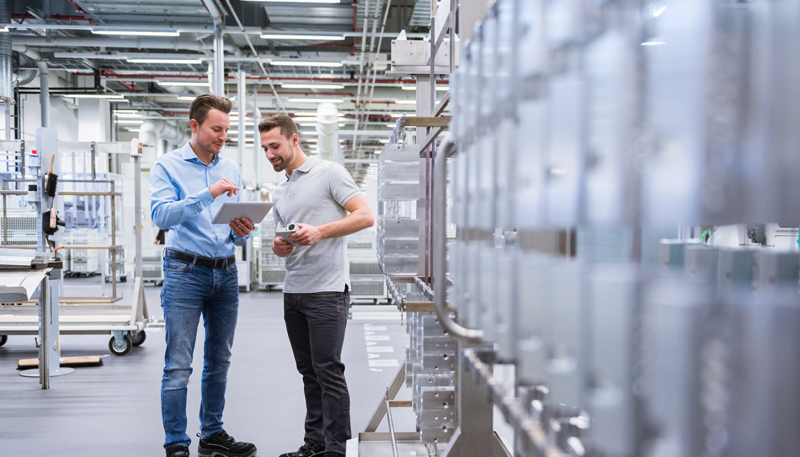 Zwei junge Männer in der Produktion Tablet in der Hand