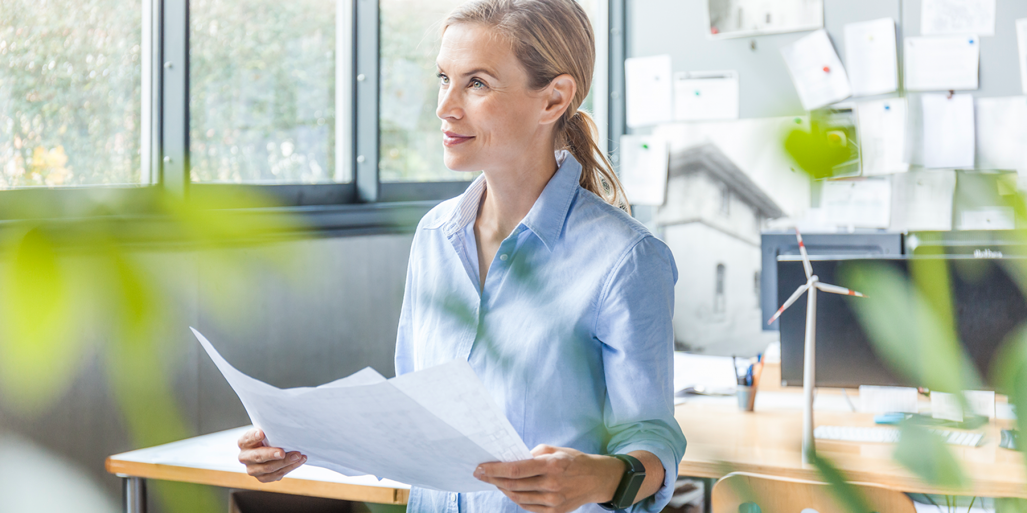 Frau im Büro hält Unterlagen in der Hand