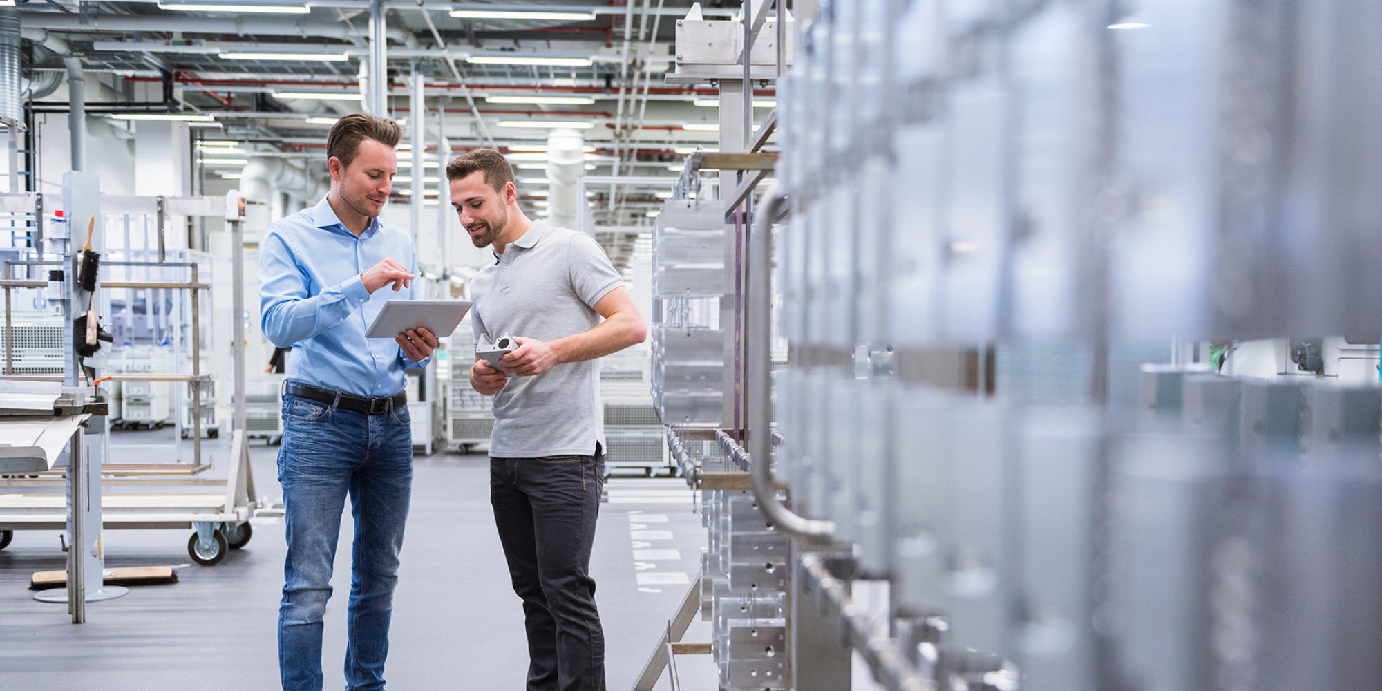 Zwei junge Männer in der Produktion Tablet in der Hand