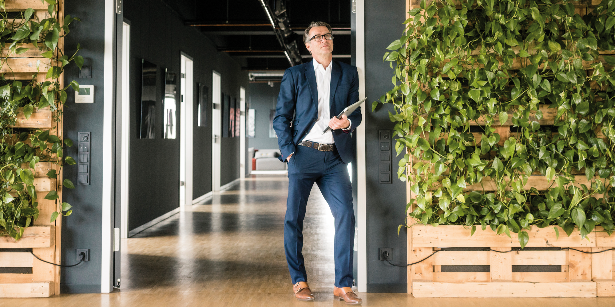 Businessman lehnt an greenwall
