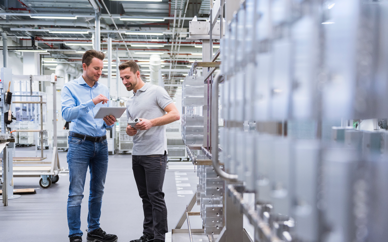 Zwei junge Männer in der Produktion Tablet in der Hand